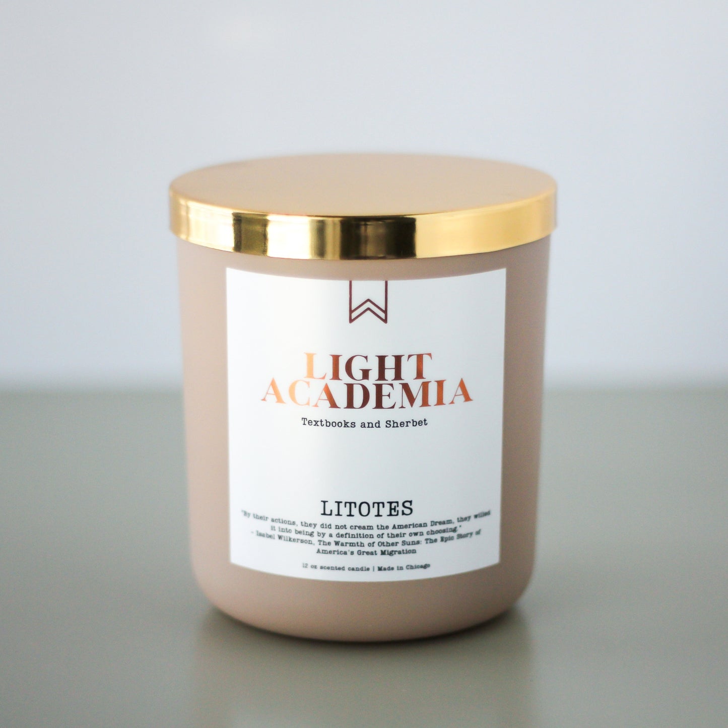 A beige candle with a gold lid, labeled 'LIGHT ACADEMIA' with the word 'LITOTES' below it.