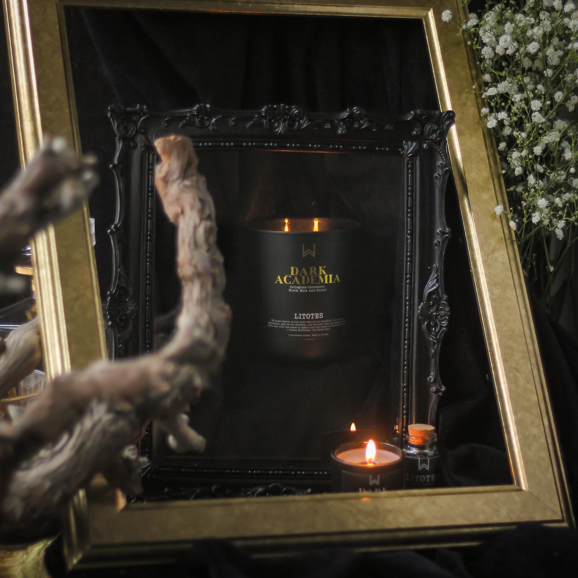 Candle in a decorative frame with gold accents and a dark background