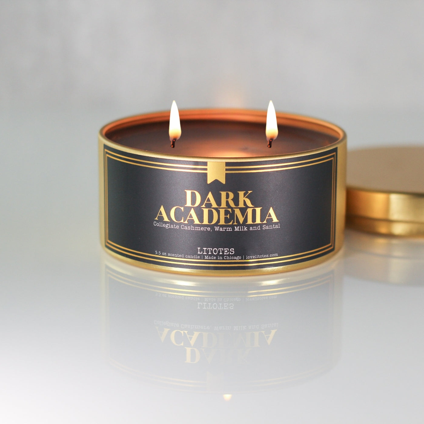 Candle in a 'Dark Academia' fragrance with two flames on a light gray background