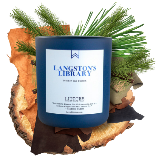 Blue candle labeled 'Langston's Library' on a wooden log with greenery